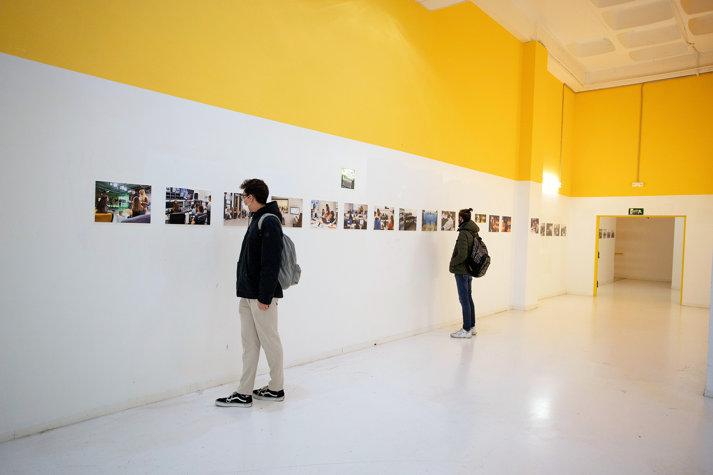 Exposición de fotografía. Dos personas observan las imágenes que cuelgan de las paredes