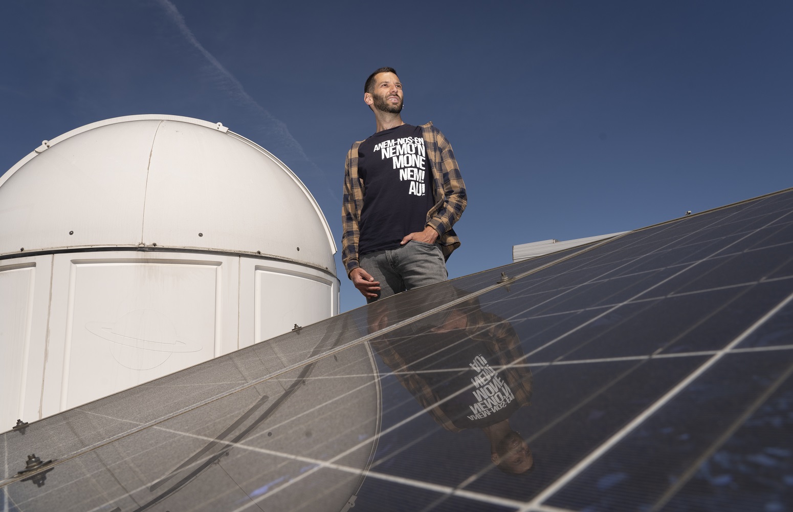 Alex Tro on a rooftop with photovoltaic panels