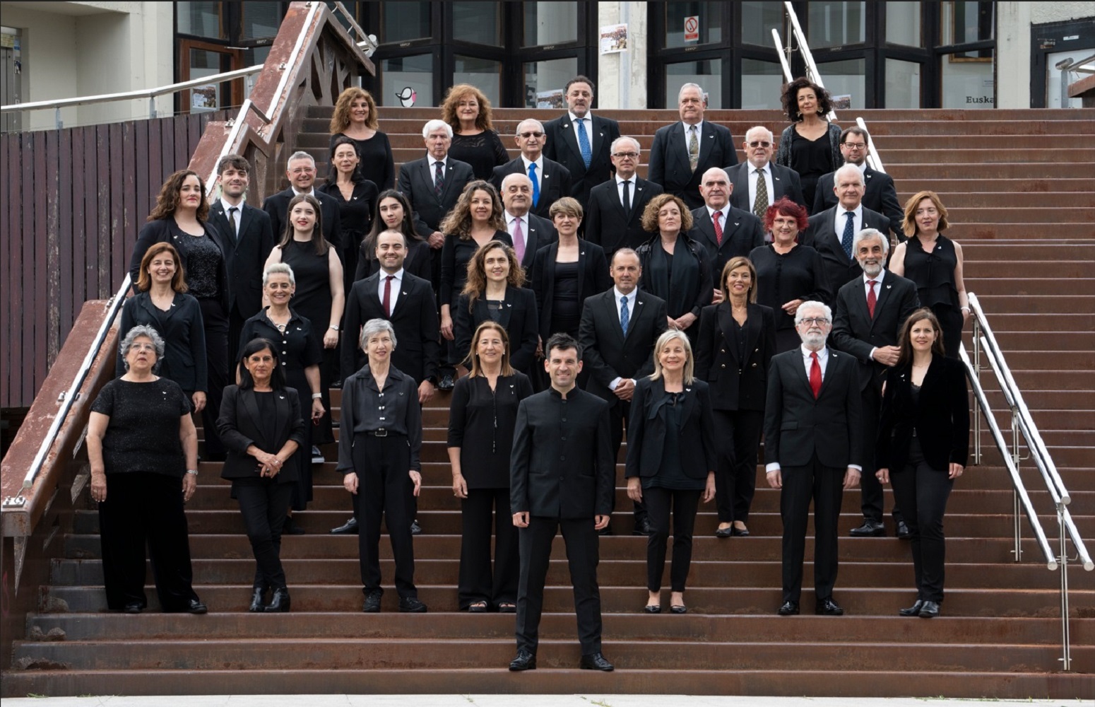 Los miembros del coro en las escaleras, frente al Paraninfo del Campus de Bizkaia.