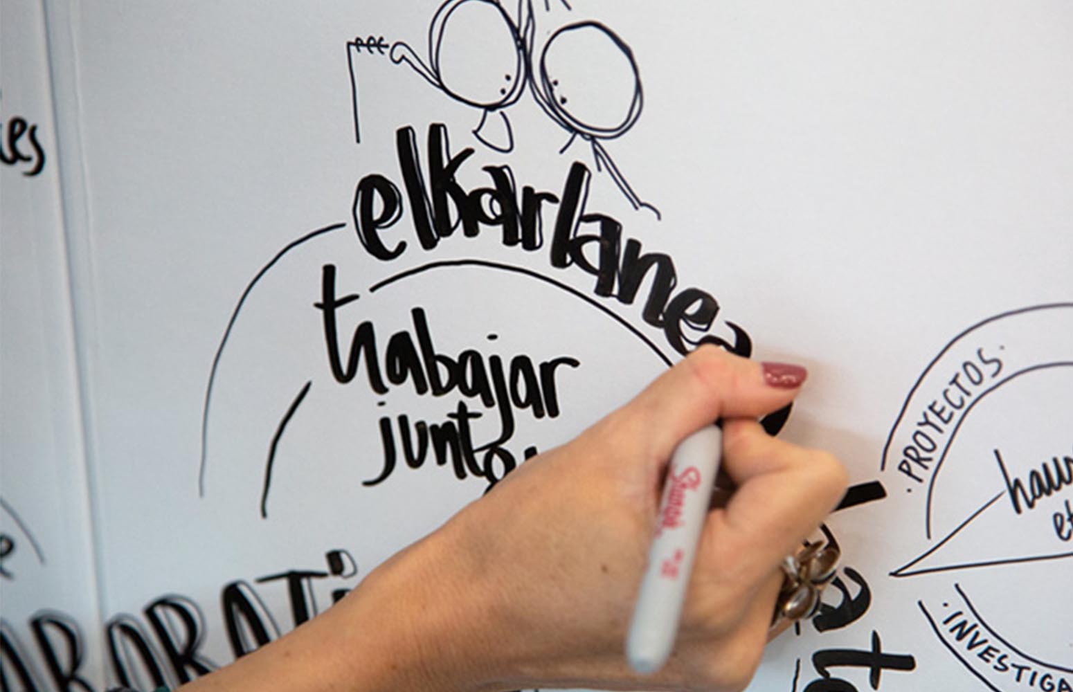 Una persona dibuja en una pizarra blanca